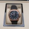 Patek Philippe — esfera negra con números grandes, caja oro rosa y correa de caucho negra
