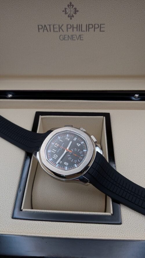 Patek Philippe — cronógrafo con esfera negra y detalles naranjas, caja de acero y correa de caucho negra