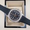 Patek Philippe — cronógrafo con esfera negra y detalles naranjas, caja de acero y correa de caucho negra
