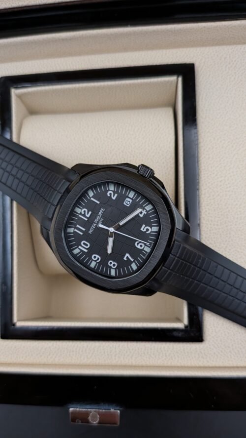 Patek Philippe — esfera negra con números grandes, caja negra y correa de caucho negra