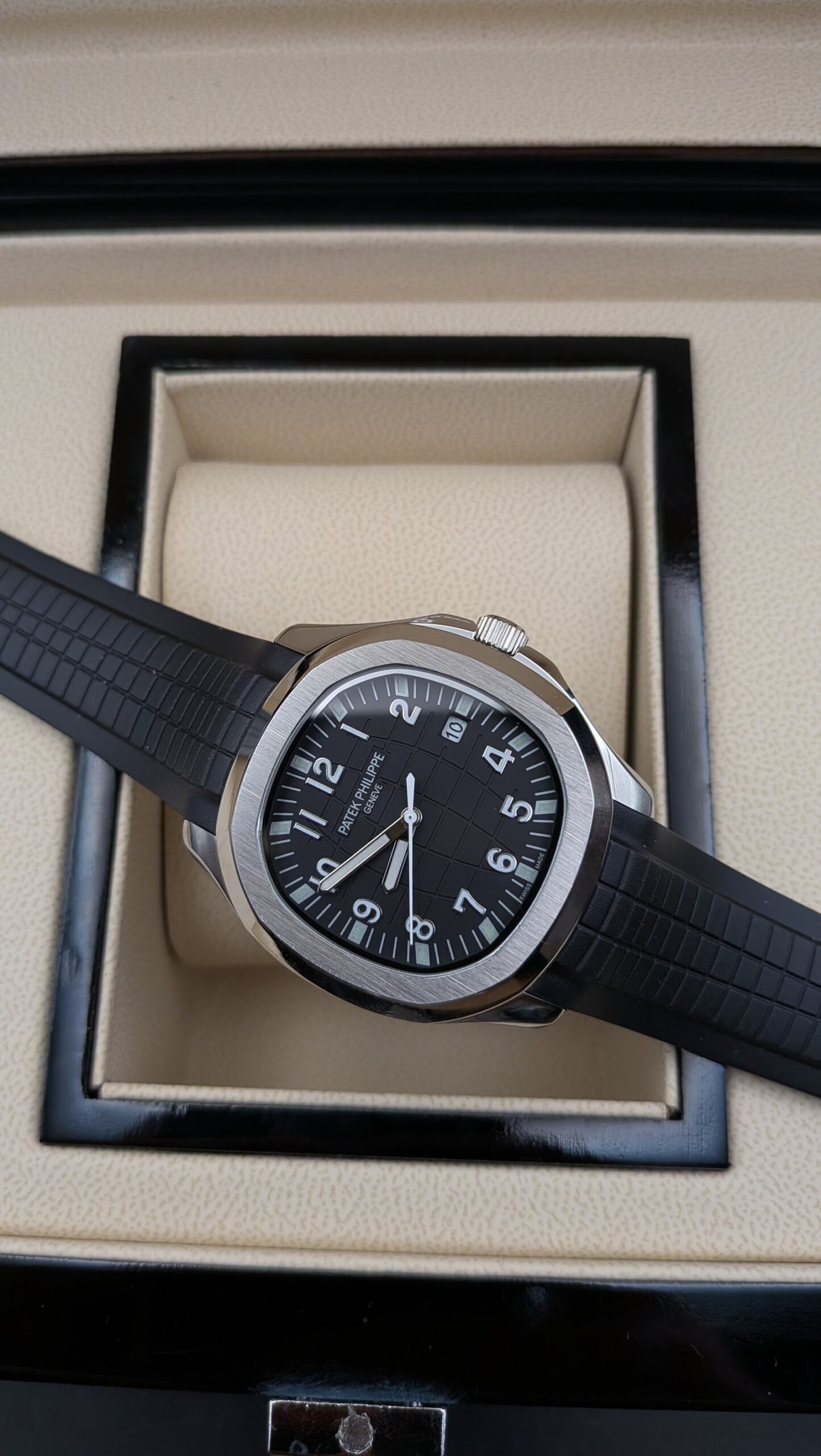 Patek Philippe — esfera negra con números grandes, caja de acero y correa de caucho negra