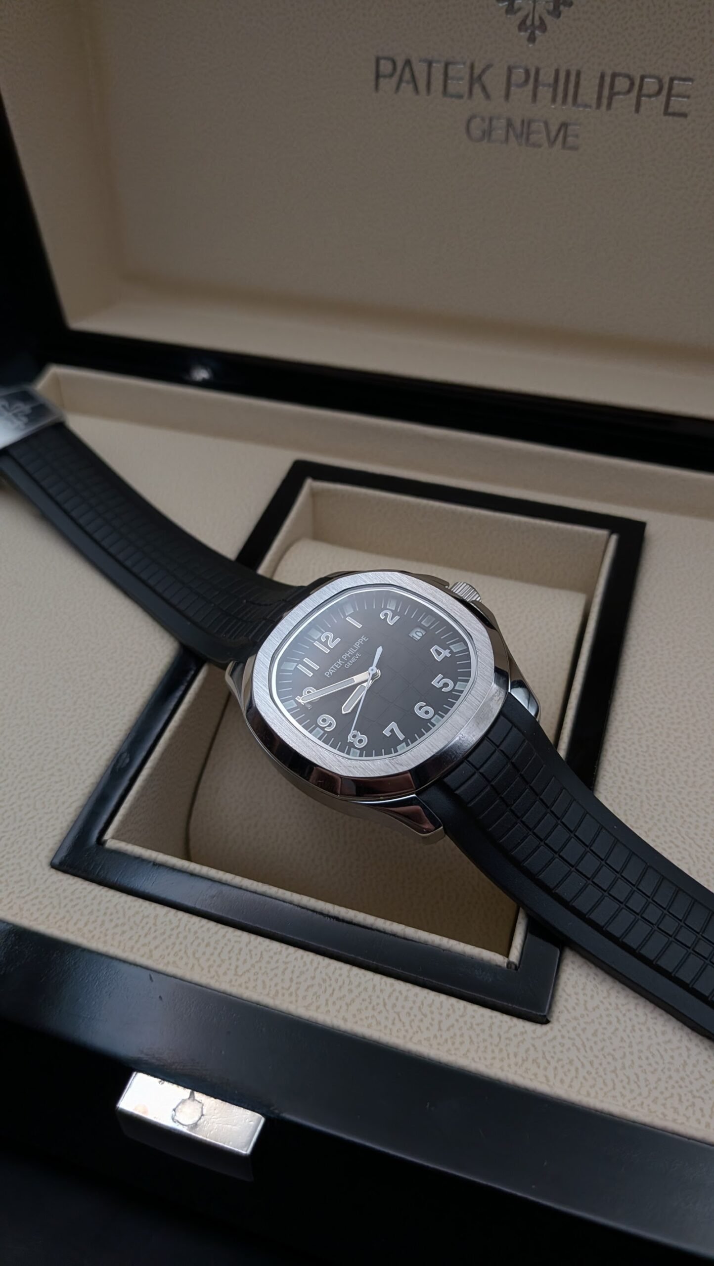 Patek Philippe — esfera negra con números grandes, caja de acero y correa de caucho negra