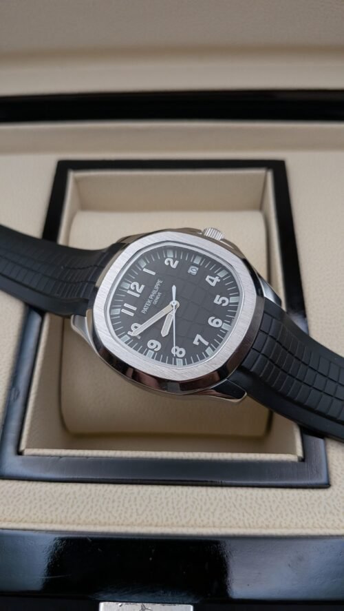 Patek Philippe — esfera negra con números grandes, caja de acero y correa de caucho negra