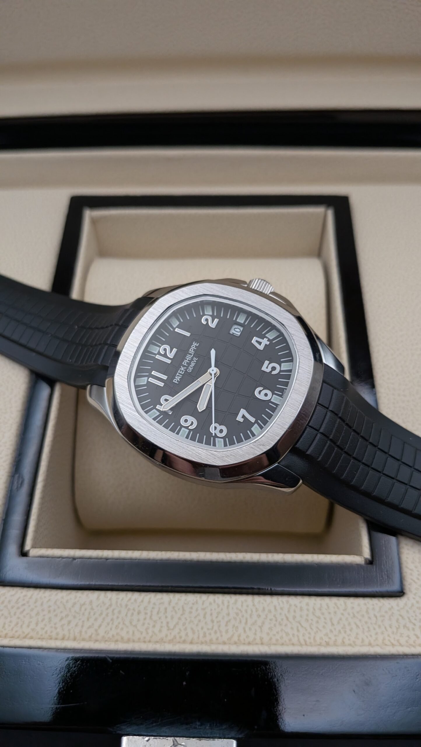 Patek Philippe — esfera negra con números grandes, caja de acero y correa de caucho negra