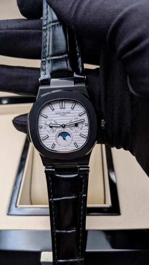 Patek Philippe — esfera blanca con fases lunares, caja negra y correa de cuero negra