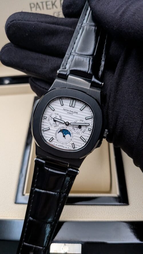 Patek Philippe — esfera blanca con fases lunares, caja negra y correa de cuero negra