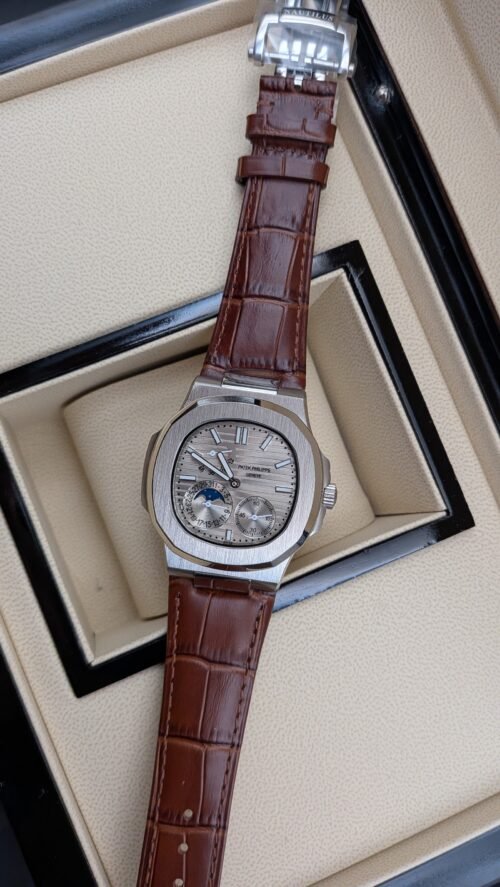 Patek Philippe — esfera plateada con fases lunares y correa de cuero marrón