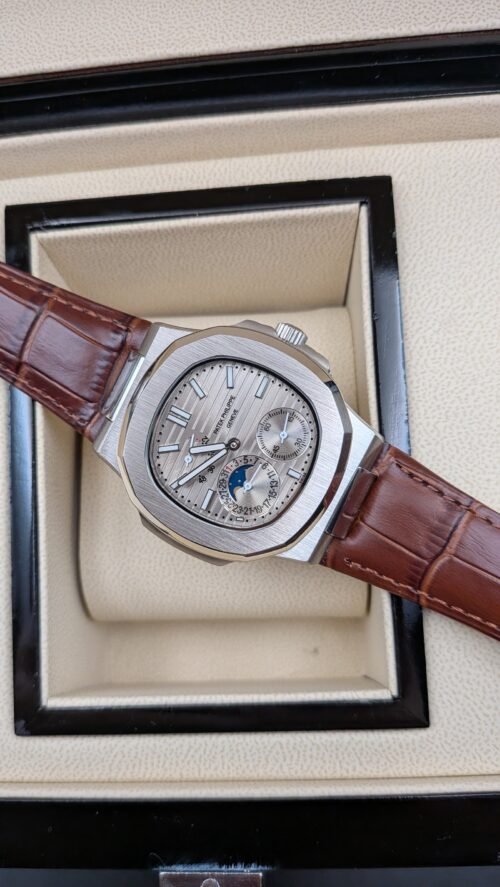 Patek Philippe — esfera plateada con fases lunares y correa de cuero marrón