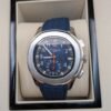 Patek Philippe — cronógrafo con esfera azul y detalles naranjas, correa de caucho azul