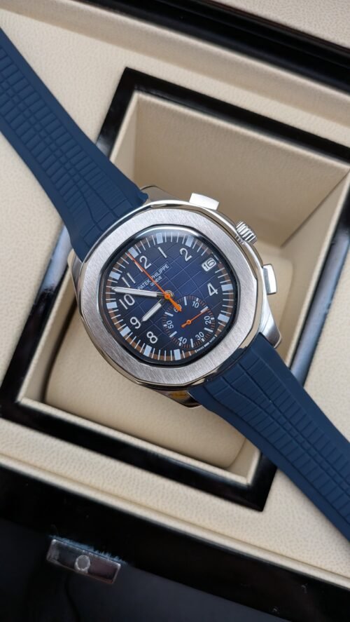 Patek Philippe — cronógrafo con esfera azul y detalles naranjas, correa de caucho azul