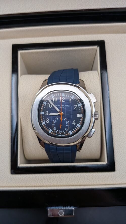 Patek Philippe — cronógrafo con esfera azul y detalles naranjas, correa de caucho azul