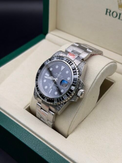 Rolex — esfera negra, bisel de piedras negras y caja con brillantes, brazalete de acero
