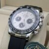 Rolex — cronógrafo con esfera plateada y subesferas negras, bisel negro y correa de caucho negra