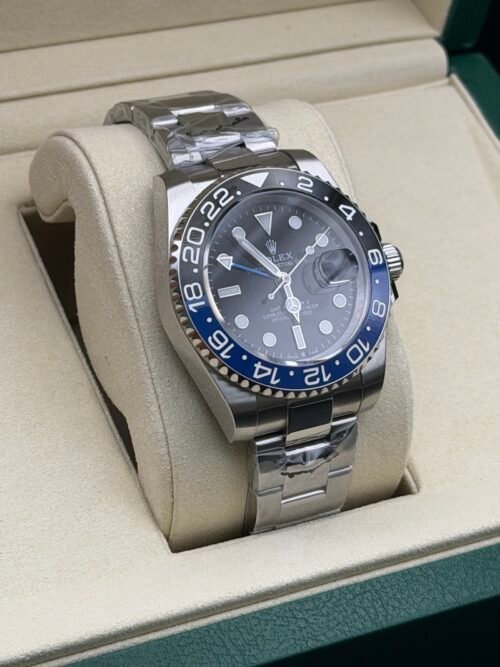 Rolex — esfera negra con doble huso horario, bisel azul y negro y brazalete de acero