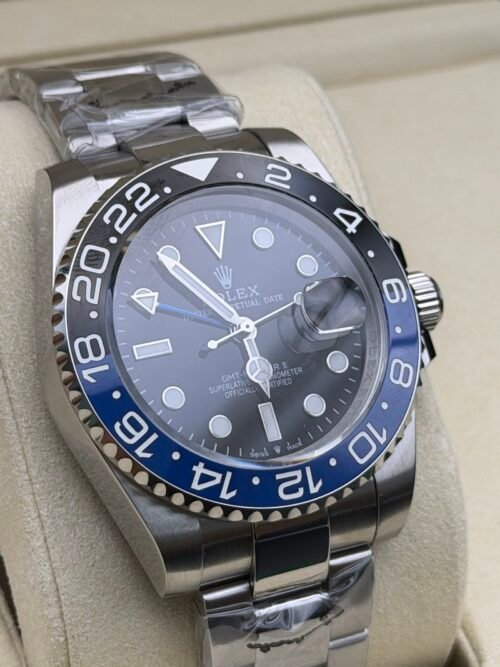 Rolex — esfera negra con doble huso horario, bisel azul y negro y brazalete de acero
