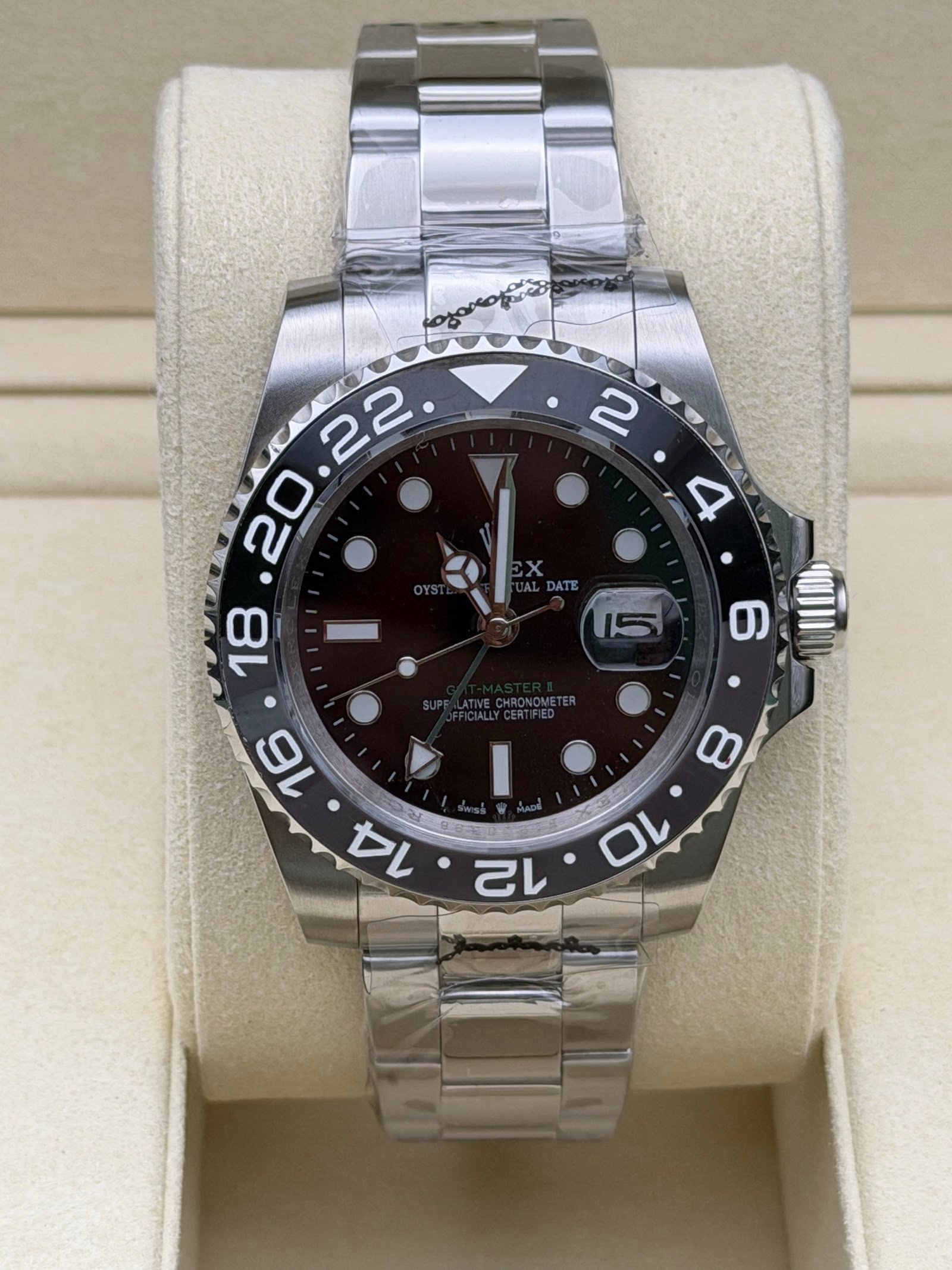 Rolex — esfera negra con doble huso horario, bisel marrón y negro y brazalete de acero