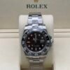 Rolex — esfera negra con doble huso horario, bisel marrón y negro y brazalete de acero