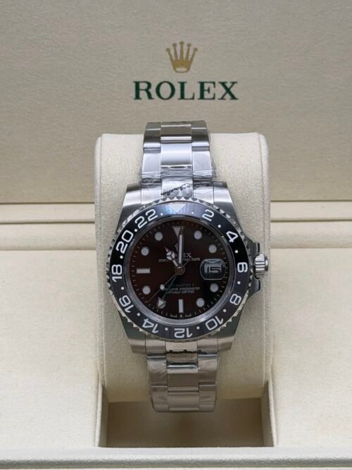 Rolex — esfera negra con doble huso horario, bisel marrón y negro y brazalete de acero