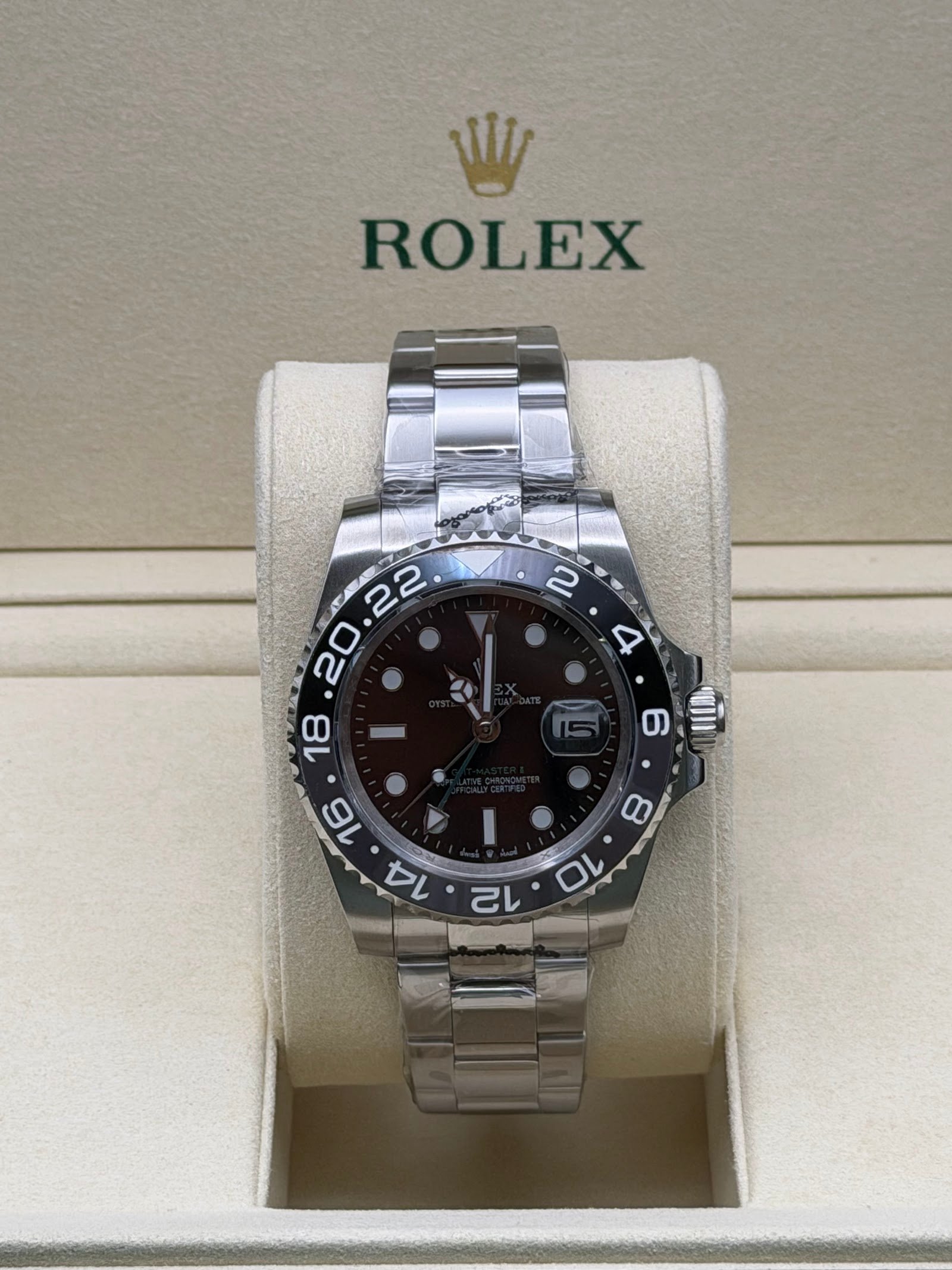 Rolex — esfera negra con doble huso horario, bisel marrón y negro y brazalete de acero