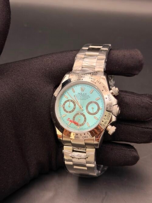 Rolex — cronógrafo con esfera turquesa y detalles rojos, caja y brazalete oro rosa