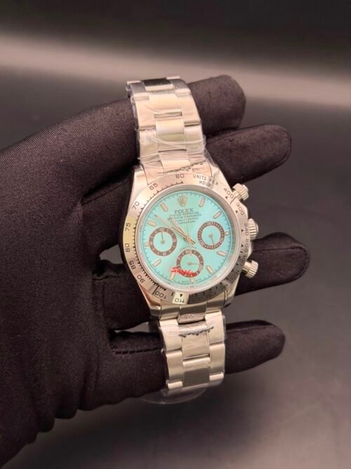 Rolex — cronógrafo con esfera turquesa y detalles rojos, caja y brazalete oro rosa