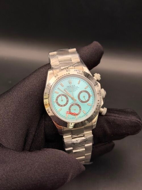 Rolex — cronógrafo con esfera turquesa y detalles rojos, caja y brazalete oro rosa