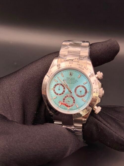 Rolex — cronógrafo con esfera turquesa y detalles rojos, caja y brazalete oro rosa