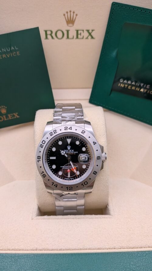 Rolex — esfera negra con aguja GMT naranja y brazalete de acero