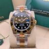 Rolex — esfera negra, bisel negro y dorado y brazalete bicolor