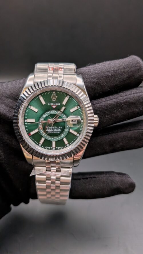 Rolex — esfera verde con calendario anual, bisel estriado y brazalete jubilee de acero en mano