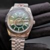 Rolex — esfera verde con calendario anual, bisel estriado y brazalete jubilee de acero en mano