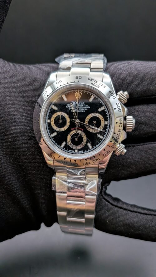 Rolex — cronógrafo con esfera negra y aros dorados, bisel de acero y brazalete de acero