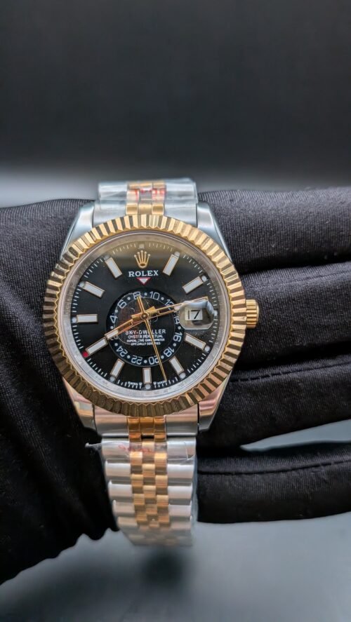Rolex — esfera negra con calendario anual, bisel dorado estriado y brazalete jubilee bicolor