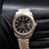 Rolex — esfera negra con calendario anual, bisel dorado estriado y brazalete jubilee bicolor