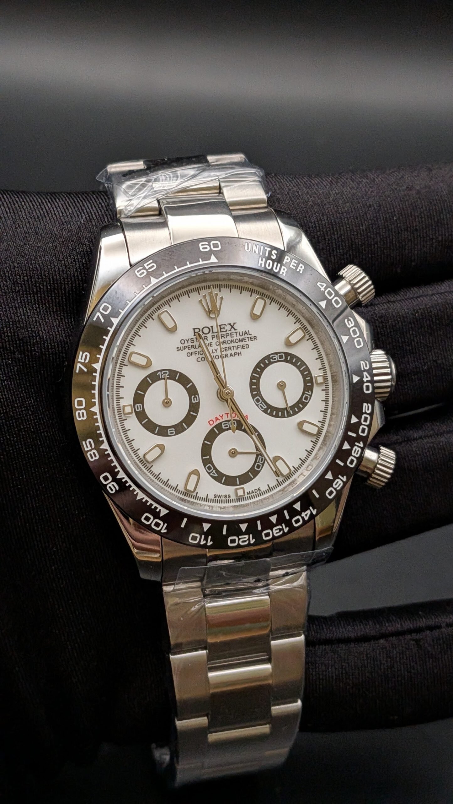 Rolex — cronógrafo con esfera blanca, bisel negro y brazalete de acero