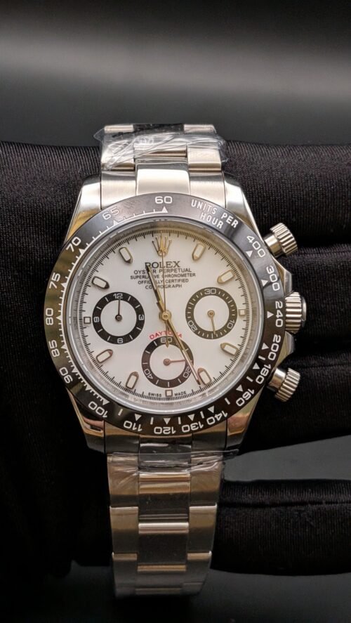 Rolex — cronógrafo con esfera blanca, bisel negro y brazalete de acero