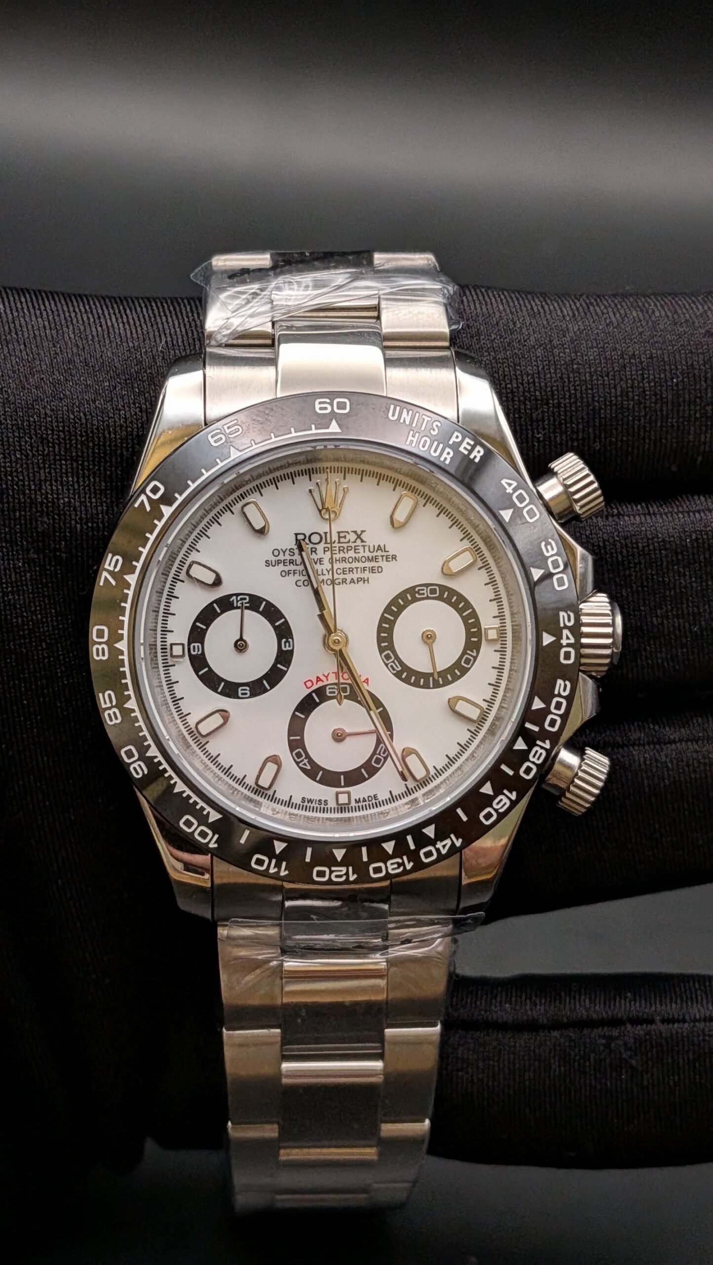 Rolex — cronógrafo con esfera blanca, bisel negro y brazalete de acero