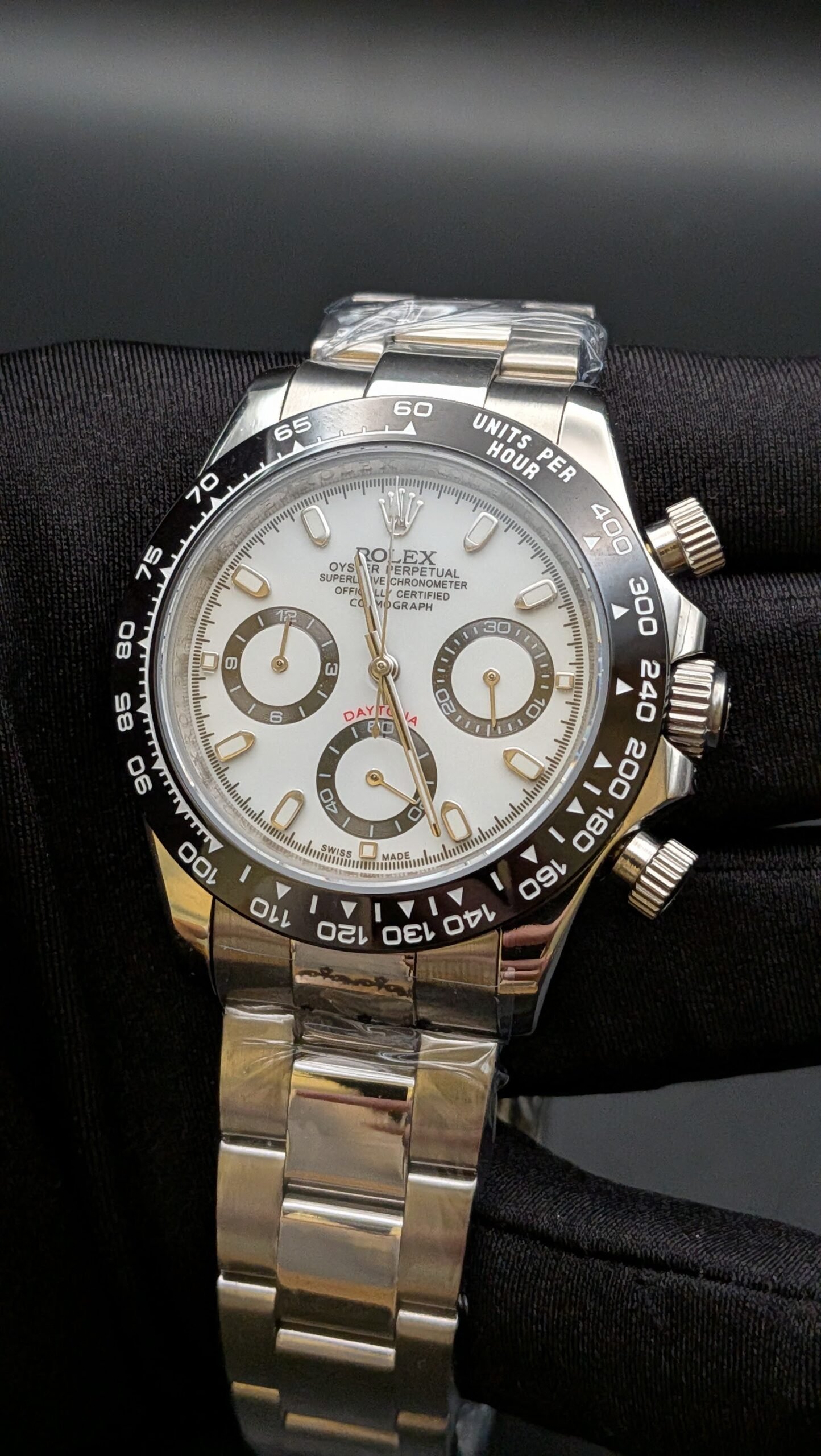 Rolex — cronógrafo con esfera blanca, bisel negro y brazalete de acero