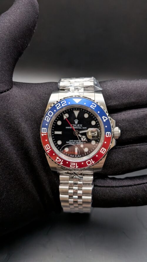 Rolex — esfera negra con doble huso horario, bisel rojo y azul y brazalete jubilee de acero