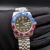 Rolex — esfera negra con doble huso horario, bisel rojo y azul y brazalete jubilee de acero