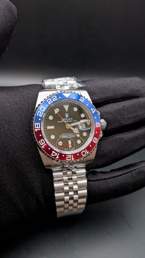Rolex — esfera negra con doble huso horario, bisel rojo y azul y brazalete jubilee de acero