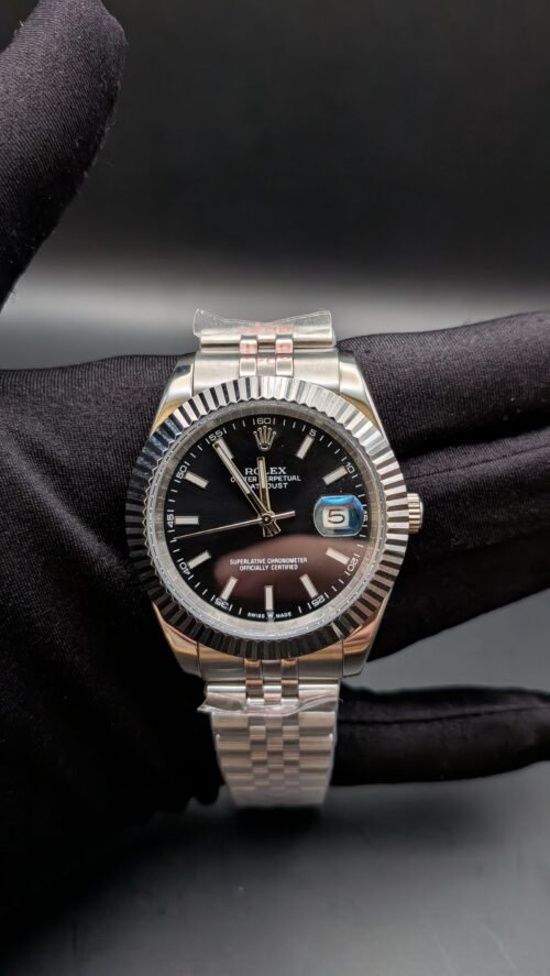 Rolex — esfera negra, bisel estriado y brazalete jubilee de acero en mano