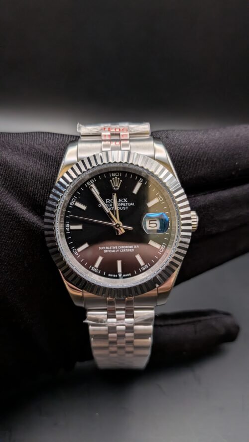 Rolex — esfera negra, bisel estriado y brazalete jubilee de acero en mano