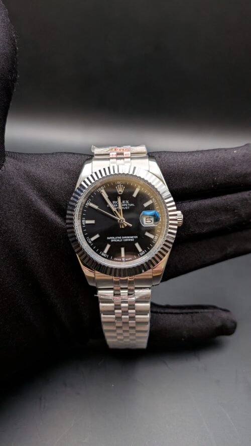 Rolex — esfera negra, bisel estriado y brazalete jubilee de acero en mano