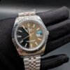 Rolex — esfera negra, bisel estriado y brazalete jubilee de acero en mano
