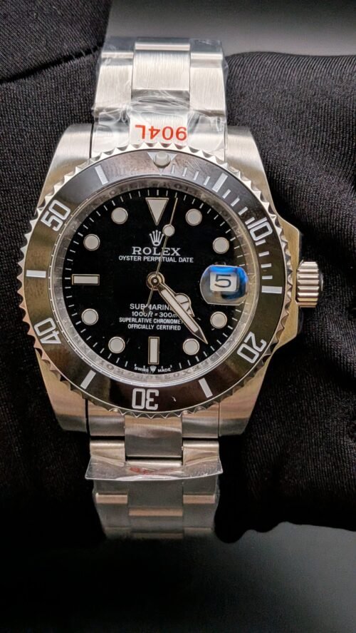 Rolex — esfera negra, bisel negro y brazalete de acero en mano