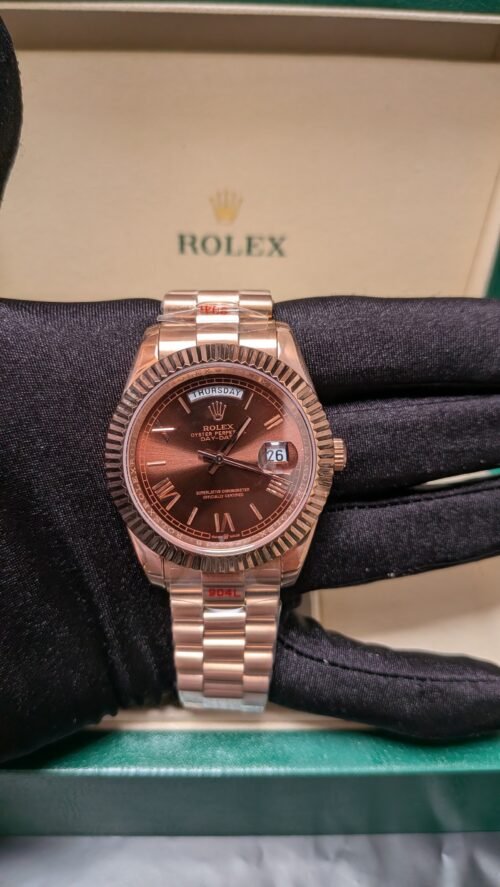 Rolex — esfera chocolate con día y fecha, bisel estriado y brazalete oro rosa