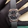 Rolex — esfera negra con calendario anual, bisel oro rosa y correa de caucho gris