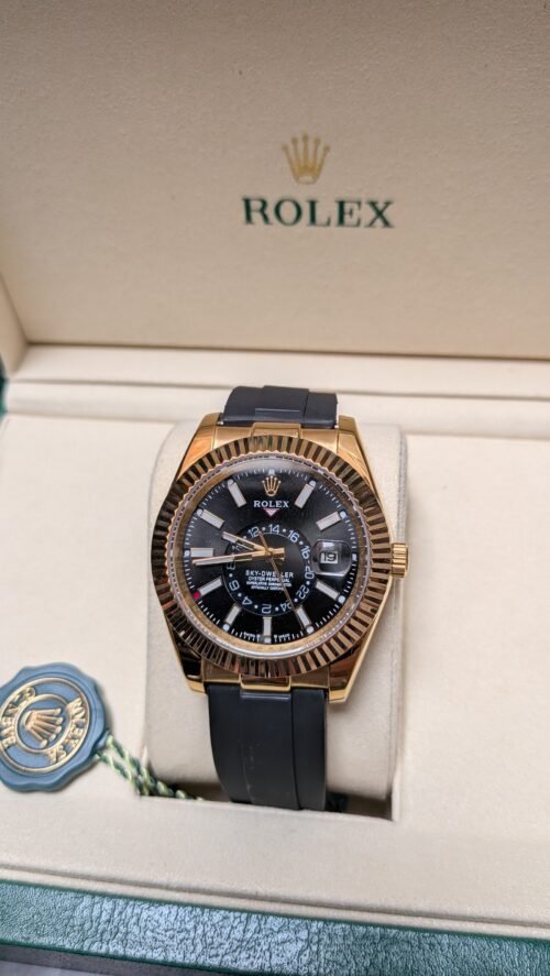 Rolex — esfera negra con calendario anual, caja dorada y correa de caucho negra