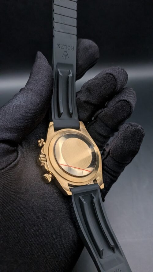 Rolex — cronógrafo con esfera turquesa y subesferas marrones, caja dorada y correa de caucho gris